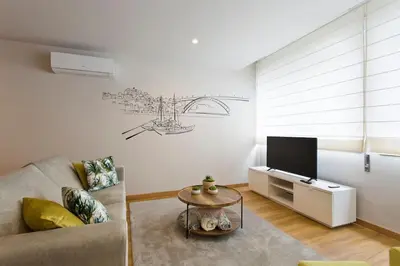 a living room with a couch and a tv at APOSENTUS - Marta's House in Porto