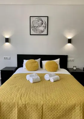 a bedroom with a large yellow bed with towels on it at Almada Downtown 402 in Porto