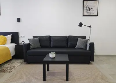 a living room with a black couch and a table at Almada Downtown 402 in Porto