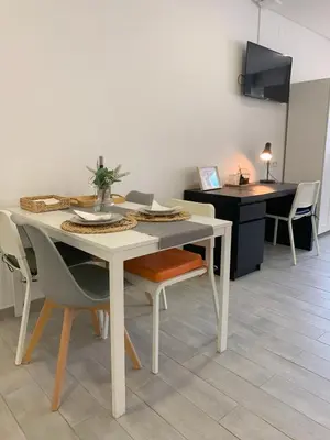 a dining room with a table and chairs and a kitchen at Almada Downtown 402 in Porto