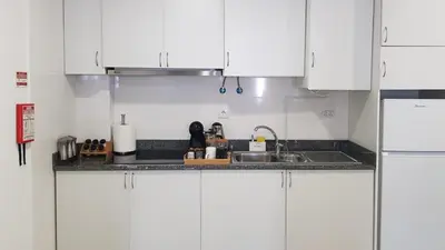 a kitchen with white cabinets and a sink at Almada Downtown 402 in Porto