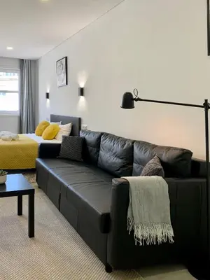 a living room with a couch and a bed at Almada Downtown 402 in Porto