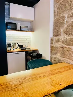 a kitchen with a wooden table and some chairs at Oporto Chic & Cozy - Mercadores in Porto