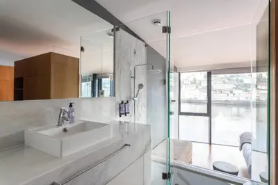a bathroom with a sink and a glass shower at MY DOURO VIEW Stunning Apartment River Front in Vila Nova de Gaia
