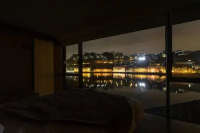 a bedroom with a view of a city at night at MY DOURO VIEW Stunning Apartment River Front in Vila Nova de Gaia