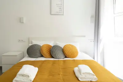 a bed with four pillows and towels on it at Almada Downtown 101 in Porto