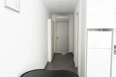 a hallway with white walls and a black chair at Almada Downtown 101 in Porto