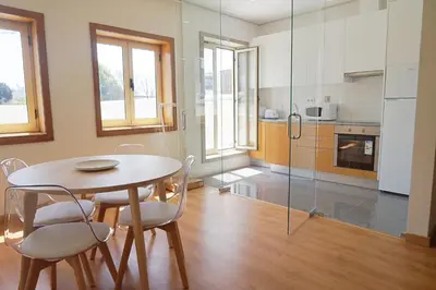 a kitchen with a table and chairs in a room at Tomás Flat in Porto