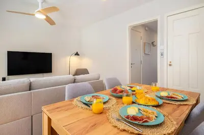 a living room with a table with plates of food on it at Whome Formosa #2 - Central 2-Bed in Prime Location Perfect to Explore Porto in Porto