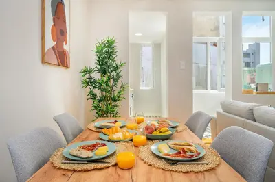 a dining room table with plates of food and orange juice at Whome Formosa #2 - Central 2-Bed in Prime Location Perfect to Explore Porto in Porto