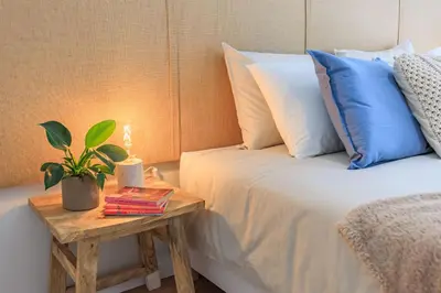 a bedroom with a bed with a table with a plant on it at Enjoy Bonfim Central 2BR Renovated Apartment by LovelyStay in Porto