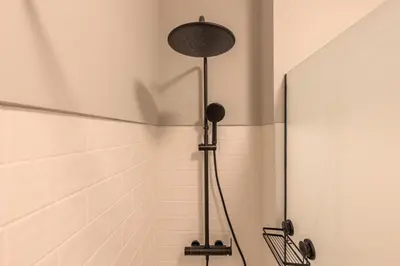 a shower in a bathroom with a white tiled wall at Enjoy Bonfim Central 2BR Renovated Apartment by LovelyStay in Porto