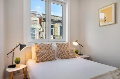 a bedroom with a white bed and a window at Whome Formosa #3 - Central 2-Bed in Prime Location Perfect to Explore Porto in Porto