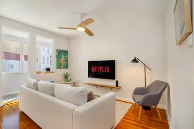 a living room with a white couch and a chair at Whome Formosa #3 - Central 2-Bed in Prime Location Perfect to Explore Porto in Porto