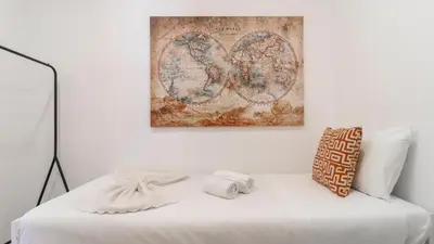 a bedroom with a white bed with a picture on the wall at Delightful Bombarda Apartment by Unique Hosts in Porto
