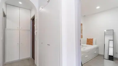 a white bathroom with white cabinets and a mirror at Delightful Bombarda Apartment by Unique Hosts in Porto