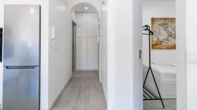 a hallway with white walls and a refrigerator at Delightful Bombarda Apartment by Unique Hosts in Porto