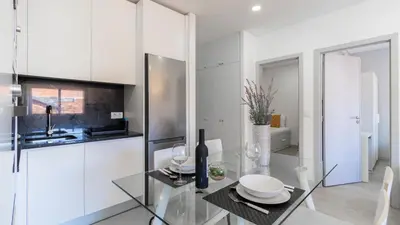 a white kitchen with a glass table and a sink at Delightful Bombarda Apartment by Unique Hosts in Porto