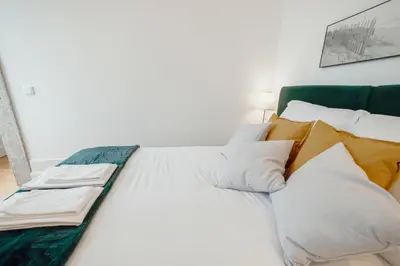 a bed with white and yellow sheets and pillows at Downtown Premium Apartment by Vacationy in Porto