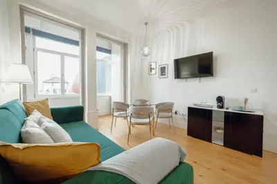 a living room with a green couch and a table at Downtown Premium Apartment by Vacationy in Porto