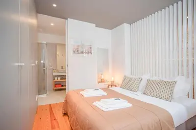 a white bedroom with a bed with two towels on it at Liiiving in Porto - Heart of Porto Mezzanine in Porto