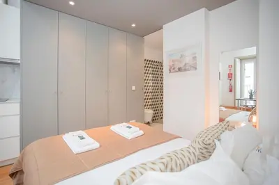 a white bedroom with a bed and white cabinets at Liiiving in Porto - Heart of Porto Mezzanine in Porto
