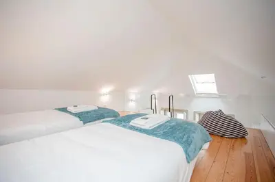 a white bedroom with two beds and a window at Liiiving in Porto - Heart of Porto Mezzanine in Porto