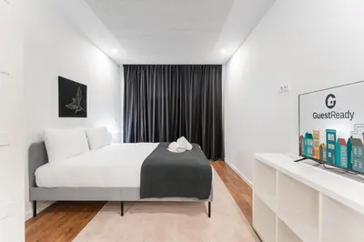 a hotel room with a bed and a tv at GuestReady - Uptown suites in Porto