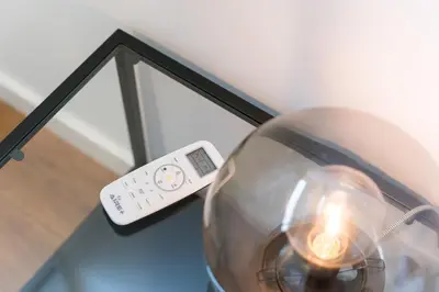 a remote control sitting on top of a glass table at GuestReady - Uptown suites in Porto