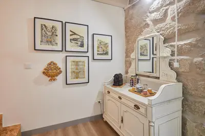 a bathroom with a white sink and pictures on the wall at Maison214 in Vila Nova de Gaia