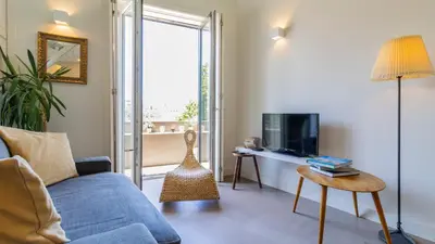 a living room with a blue couch and a tv at Aposentus - Stylish Downtown Loft in Porto