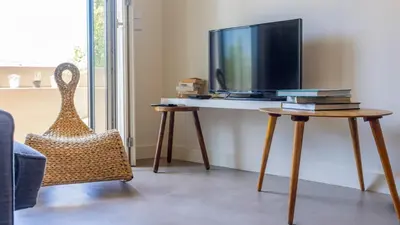a living room with a tv and a table with a chair at Aposentus - Stylish Downtown Loft in Porto