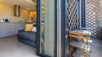 a room with a mirror and a couch and a chair at Aposentus - Stylish Downtown Loft in Porto