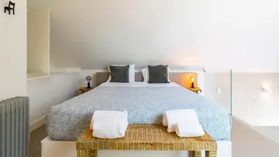 a bedroom with a large bed with two white towels at Aposentus - Stylish Downtown Loft in Porto