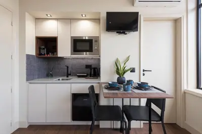a kitchen with a table and chairs and a sink at DOISPONTOZERO Júlio Dinis in Porto