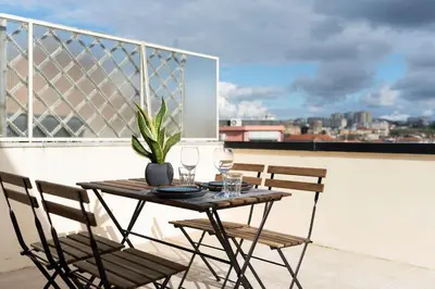 a bedroom with a bed and a table with dishes on it at DOISPONTOZERO Júlio Dinis in Porto