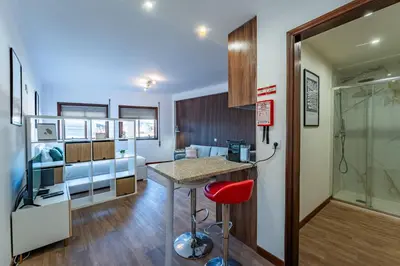 a bathroom with a glass shower and a picture on the wall at Plan C Downtown Apartment in Porto