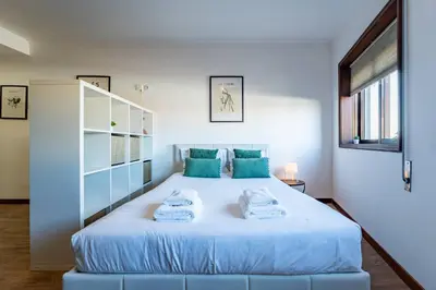 a bedroom with a bed with towels on it at Plan C Downtown Apartment in Porto