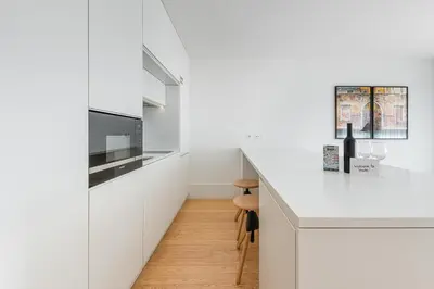 a kitchen with white cabinets and a white counter top at Door 65 - Historical Center Apartments in Porto