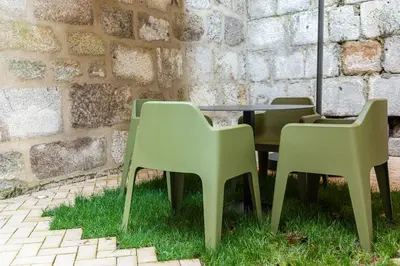 two chairs and a table in front of a brick wall at Door 65 - Historical Center Apartments in Porto