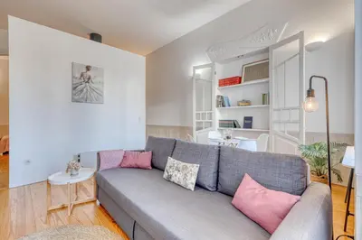 a living room with a gray couch and pink pillows at Formosa Patio with Free Parking in Porto
