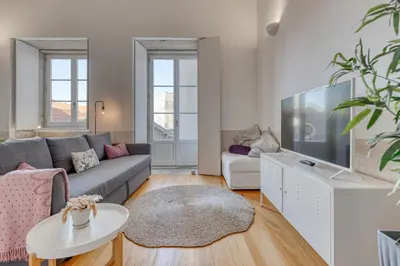 a living room with a couch and a tv at Formosa Patio with Free Parking in Porto