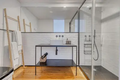 a bathroom with a sink and a glass shower at Formosa Patio with Free Parking in Porto