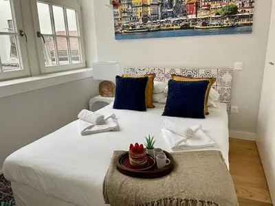a bedroom with a large white bed with blue pillows at Artistic Neighborhood Luxury in Porto