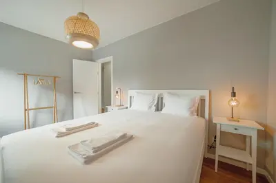 a white bedroom with a white bed with towels on it at Crystal Palace Garden Stylish Apartment by Vacationy in Porto