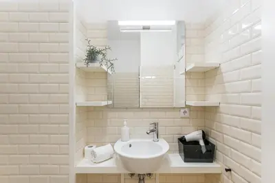a white bathroom with a sink and a mirror at GuestReady - San Sebastian Studios in Porto