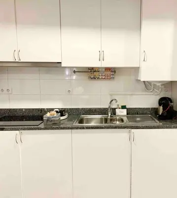 a kitchen with white cabinets and a sink at Almada Downtown 102 in Porto