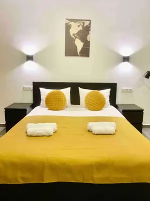 a large yellow bed with two pillows on it at Almada Downtown 102 in Porto