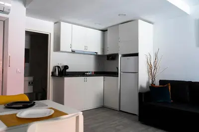 a small kitchen with white cabinets and a table at Almada Downtown 103 in Porto