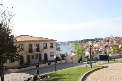 a group of people sitting on the grass near a building at Casa do Pilar - D. Luís I in Vila Nova de Gaia